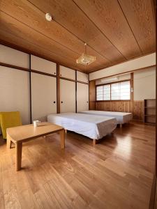 a bedroom with a large bed and a table at 39guest house in Ibusuki