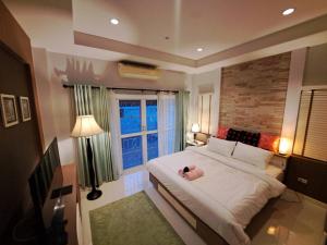 a bedroom with a large bed with a stuffed animal on it at Jacuzzi Pool Villa in Ban Huai Yai