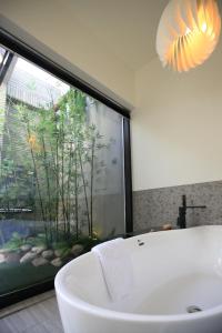 uma banheira na casa de banho com uma grande janela em Luo Hotel em Daegu