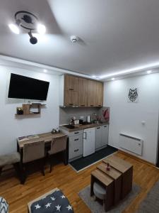 uma sala de estar com uma cozinha com uma mesa em Wolf Apartments SPA with GARAGE em Kopaonik