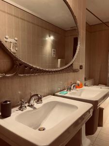 un bagno con due lavandini e un grande specchio di Residence Tenuta Gambalonga a Cinto Euganeo