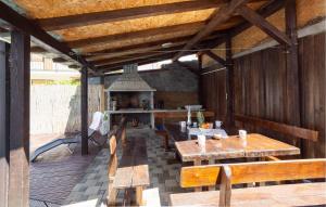 eine Außenküche mit Holztischen und Bänken in der Unterkunft Awesome Apartment In Kastel Kambelovac With Jacuzzi in Kaštela