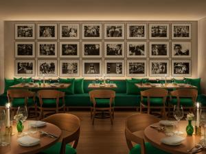 a restaurant with tables and green seats and pictures on the wall at The Tokyo EDITION, Ginza in Tokyo +40 photos