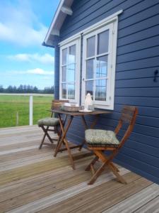 uma casa azul com uma mesa e cadeiras num deque em Little, nice cottage for 2 with beautiful view em Lokken