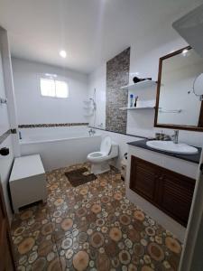 a bathroom with a sink and a toilet and a mirror at Jacuzzi Pool Villa in Ban Huai Yai