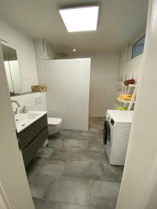 Baño blanco con lavabo y aseo en Apartment Igelsdorf, en Baiersdorf