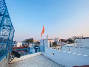 un balcón con bandera en la parte superior de un edificio en The Narayan Bhawan , ramanuj ashram ,haridas nagar ,ramkot ayodhya ji en Ayodhya