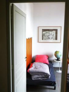 a bed with two red pillows in a room at Duplex 120m² Central - Parking in Montpellier