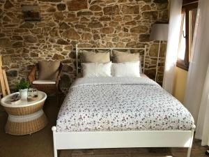1 dormitorio con cama y pared de piedra en One bedroom house with shared pool terrace and wifi at Biescas en Biescas