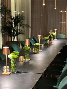 a long table with lamps and plants on it at We Me Suite Hotel in Riccione