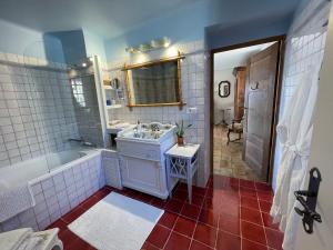 Muller's Bed & Breakfast في Bargemon: حمام مع حوض ومغسلة وحوض استحمام