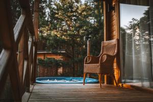 a wicker chair sitting on a porch next to a pool at Miško kraštas in Vileikiai