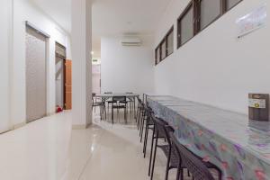 a dining room with chairs and a long counter at Reddoorz near Kiara Artha Park in Bandung