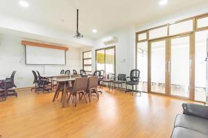 a conference room with a table and chairs and a whiteboard at Reddoorz near Kiara Artha Park in Bandung