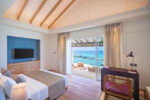 a bedroom with a bed and a view of the ocean at Ellaidhoo Maldives by Cinnamon in Hangnaameedhoo