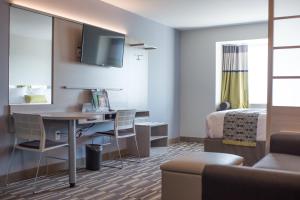 ein Hotelzimmer mit einem Schreibtisch und einem Bett in der Unterkunft Microtel Inn & Suites by Wyndham West Fargo Near Medical Center in West Fargo