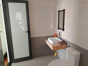 ein Badezimmer mit einem weißen WC und einem Waschbecken in der Unterkunft Thuong Da Riverside Homestay in Hoi An