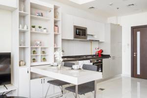 cocina blanca con mesa blanca y sillas en Modern Studio in Arjan-Dubailand, en Dubái