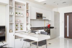 a white kitchen with a white table and chairs at Modern Studio in Arjan-Dubailand in Dubai