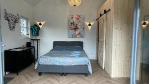 Flora’s B&B في Landsmeer: غرفة نوم فيها سرير وخزانة