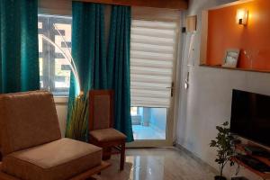 a living room with a chair and a window at Suite ultra moderne Wi-Fi in Yaoundé