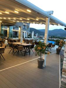 a restaurant with tables and chairs on a deck at Panorama Hill Hotel in Iraklitsa