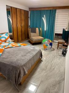 - une chambre avec un lit, une chaise et un bureau dans l'établissement Suite ultra moderne Wi-Fi, à Yaoundé