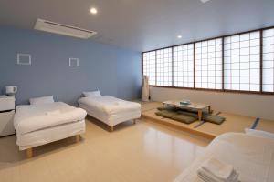 a large room with two beds and a table at Iwatoyama Hostel in Kyoto