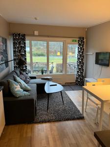 uma sala de estar com um sofá e uma mesa em Hällestrand nr 6 Seaview em Strömstad