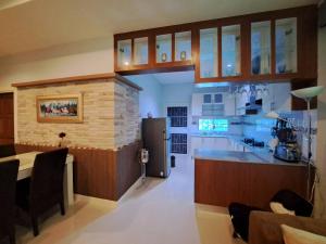 a large kitchen with a counter and a refrigerator at Jacuzzi Pool Villa in Ban Huai Yai