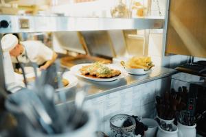 a chef preparing food in a restaurant kitchen at STF Korrö Hotell in Linneryd