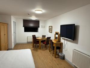 a room with a bed and a table and a television at The Radnorshire Arms Hotel in Presteigne