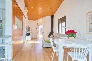 a kitchen and living room with a white table and chairs at Preciosa casa en el Maresme con jardín in Cabrils