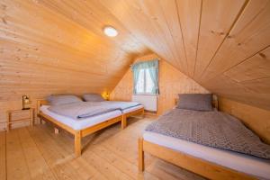 sypialnia z 2 łóżkami w drewnianym domku w obiekcie Chaloupka Kouty w mieście Loučná nad Desnou