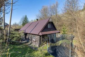 mały domek z czerwonym dachem w lesie w obiekcie Chaloupka Kouty w mieście Loučná nad Desnou