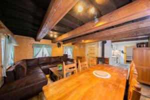 a living room with a wooden table and leather furniture at Chaloupka Kouty in Loučná nad Desnou