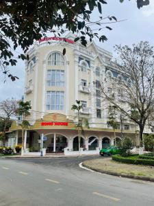 a large white building with a car parked in front of it at KHÁCH SẠN ROMO in Quang Ngai