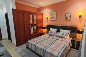 Schlafzimmer mit einem Bett und orangefarbenen Wänden in der Unterkunft Résidence Axel in Pointe-Noire