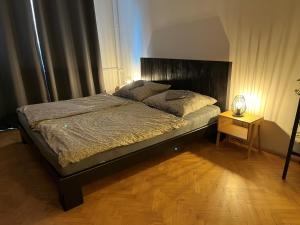 Schlafzimmer mit einem großen Bett mit einem Kopfteil aus Holz in der Unterkunft Útulný byt blízko centra in Koliba