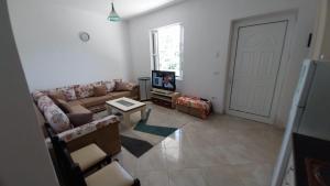a living room with a couch and a tv at Holiday Apartment in Draç