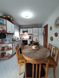 eine Küche mit einem Tisch und Stühlen im Zimmer in der Unterkunft Casa da Rapadoira 