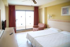 a hotel room with a bed and a chair at ALEGRIA Fenix Family in Roquetas de Mar
