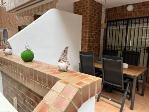 a patio with a table and cats sitting on a brick wall at Planta baja en Magic World in Oropesa del Mar