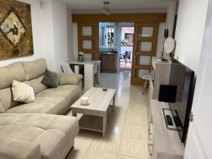 a living room with a couch and a tv at Planta baja en Magic World in Oropesa del Mar