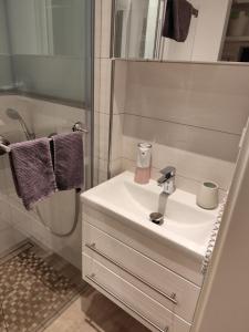 a white bathroom with a sink and a shower at Ferienhaus Liewer 