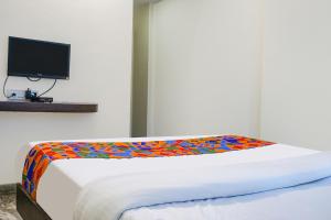 1 dormitorio con 1 cama con una manta colorida en FabHotel Gokul Lodge, en Pune