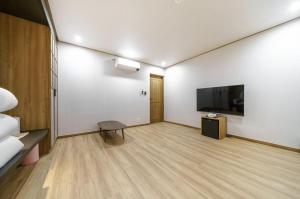 Una televisión o centro de entretenimiento en DongBaek Hotel Okpo