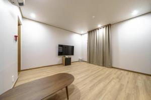 Una televisión o centro de entretenimiento en DongBaek Hotel Okpo