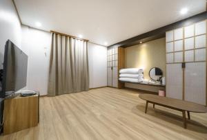 Una televisión o centro de entretenimiento en DongBaek Hotel Okpo