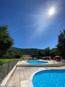 une grande piscine à côté d'une clôture dans l'établissement Camping Les Gorges de l'Hérault, à Sumène